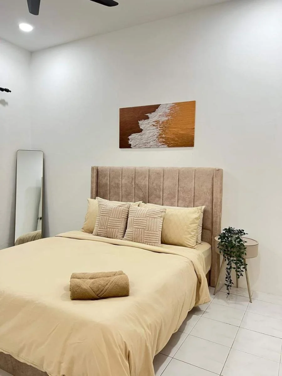 Bilik utama Ayaani Homestay dengan katil queen, headboard beludru dan aircond